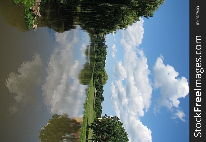 A bright blue sky, white fluffy clouds, a lazy river, green grass & weeping willow trees. A bright blue sky, white fluffy clouds, a lazy river, green grass & weeping willow trees.