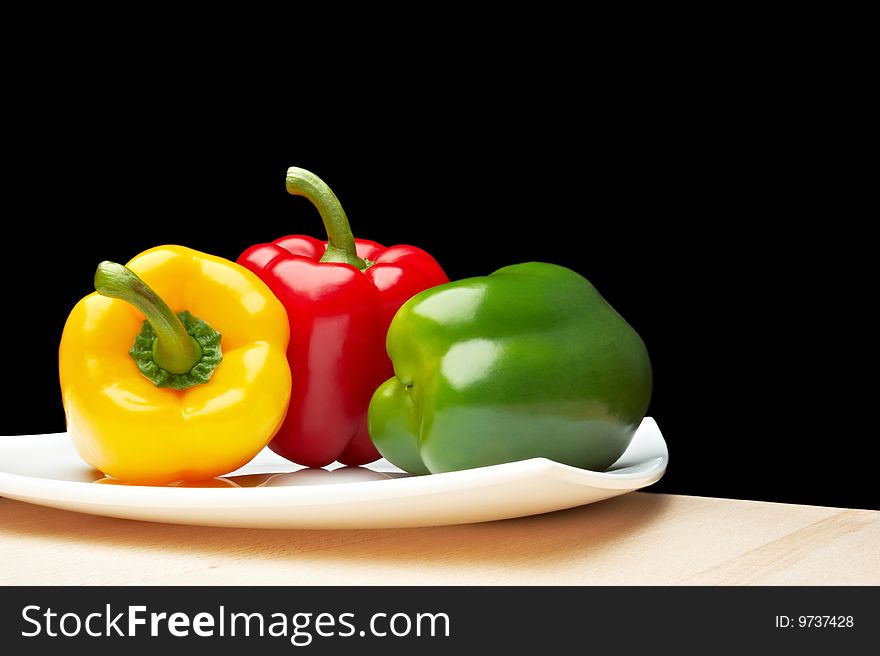 Vegetables - Peppers on white plate (black background)