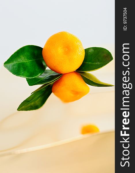 Reflection of tangerine with leaves on the smooth surface. Reflection of tangerine with leaves on the smooth surface