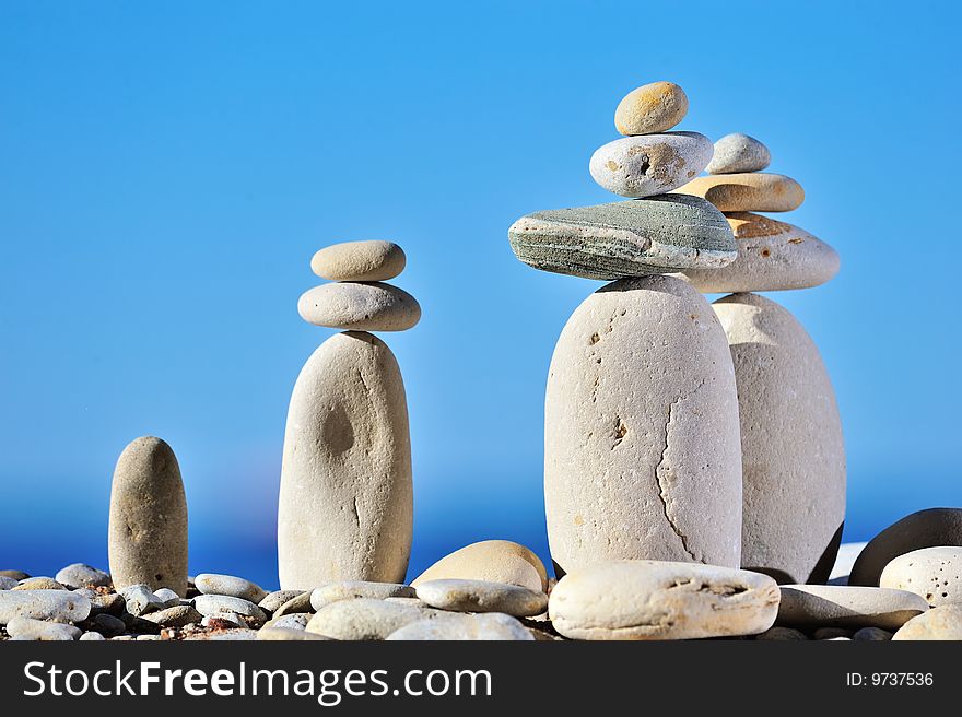 White long pebbles on a background of blue sky. White long pebbles on a background of blue sky