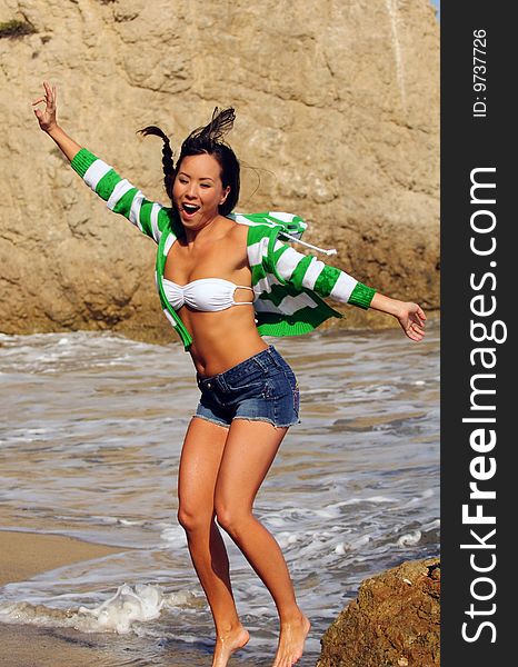 Attractive young woman jumping for joy at beach