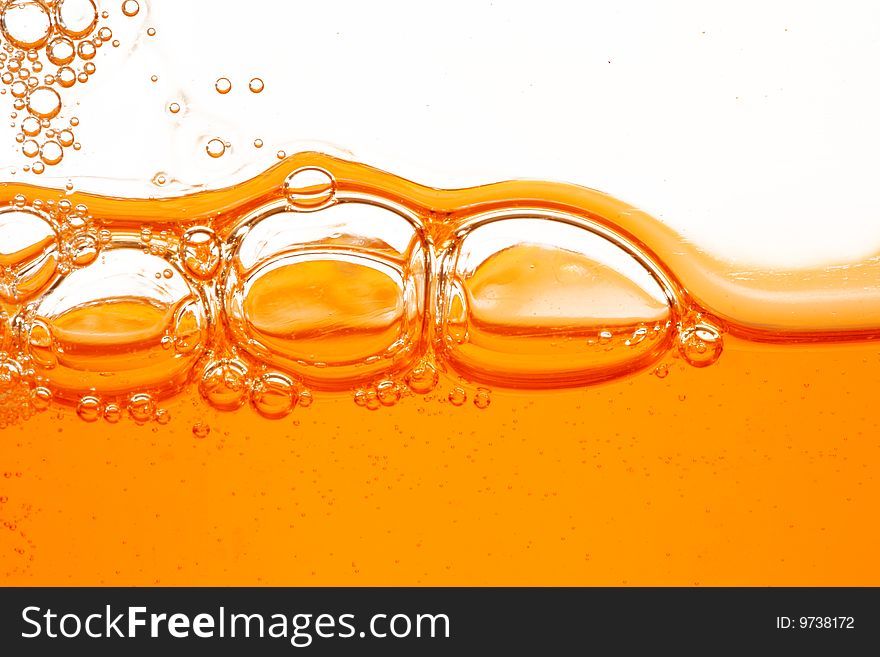 Macro of soap orange bubbles against white background