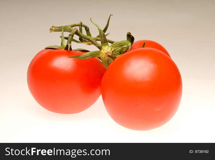Three red tomatoes with bottom illumination