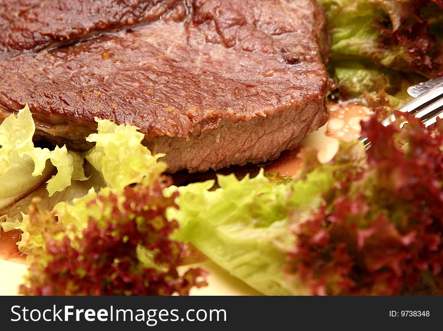 Tasty beef stÐµak in salad leaves. Bon appetit.