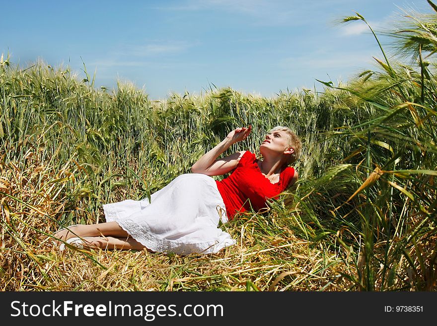 Young attractive woman dreaming in field