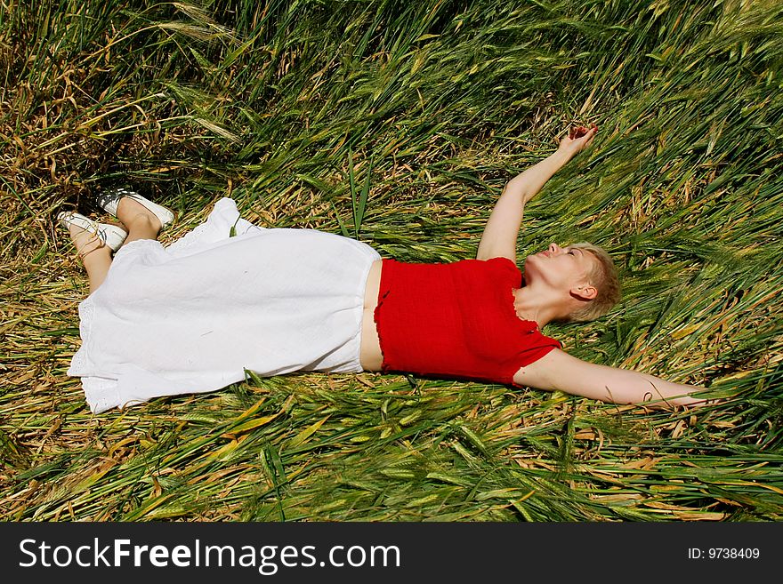 Young attractive girl resting in green field