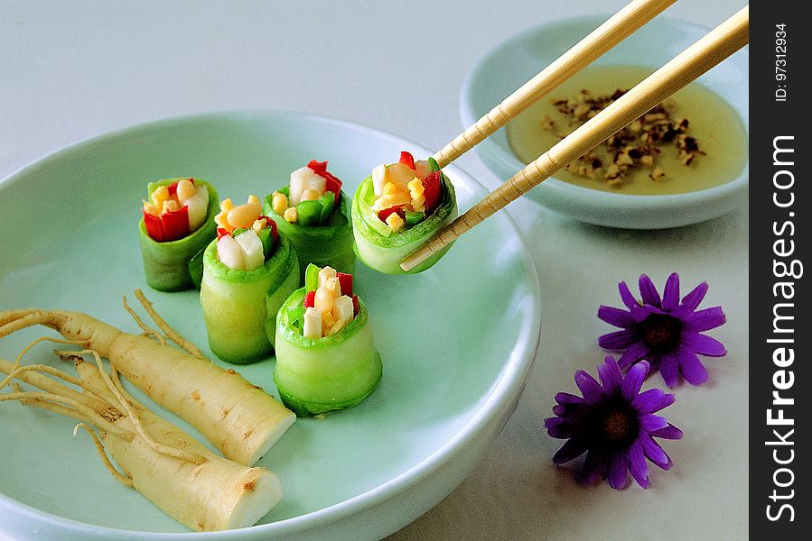 Vegetable Covered With Food Wrapper on Green Bowl With Chopstick Beside Purple Flower