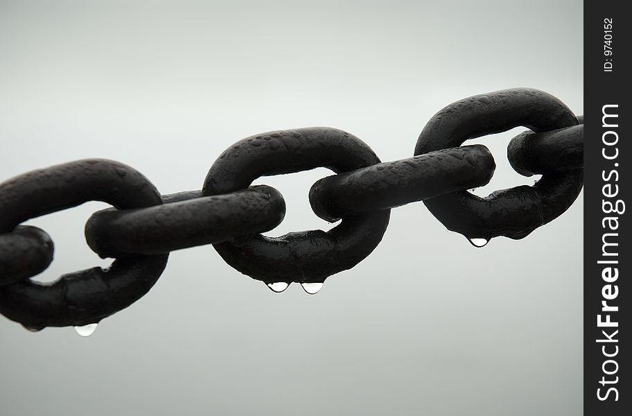 Links of chain with droplets on white background