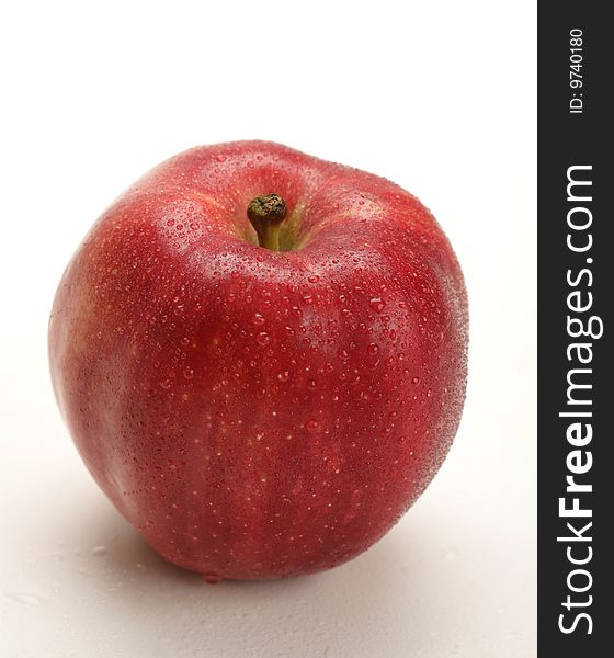 Fresh red apple with water drops on white background
