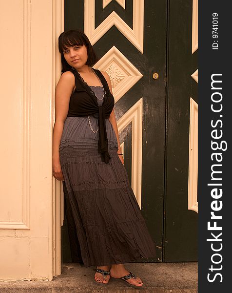 Color Photograph of a young Hispanic woman leaning in a doorway. Color Photograph of a young Hispanic woman leaning in a doorway