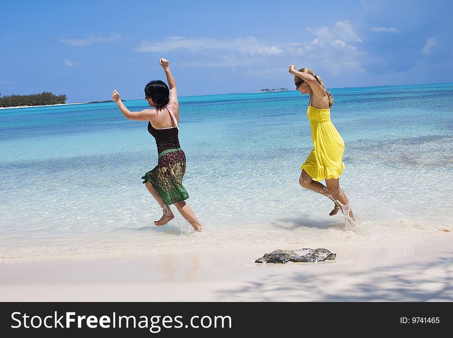 Two women run along the beach having lots of fun on their Caribbean Vacation. Two women run along the beach having lots of fun on their Caribbean Vacation