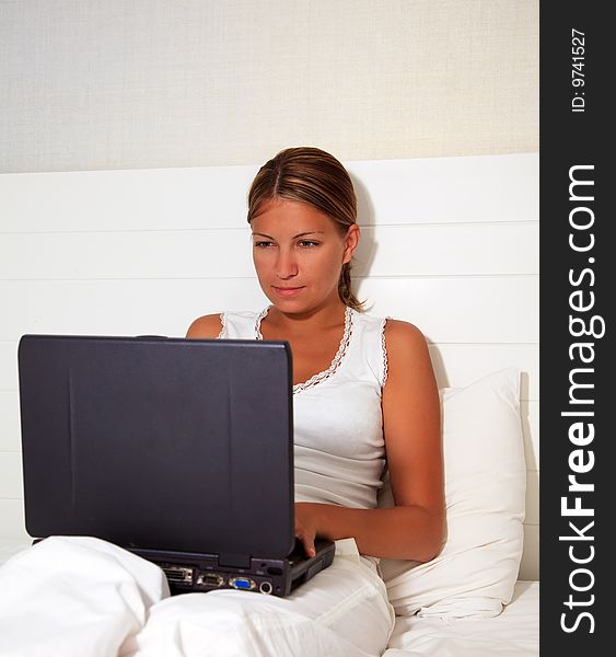 Woman In Bed Working On Laptop