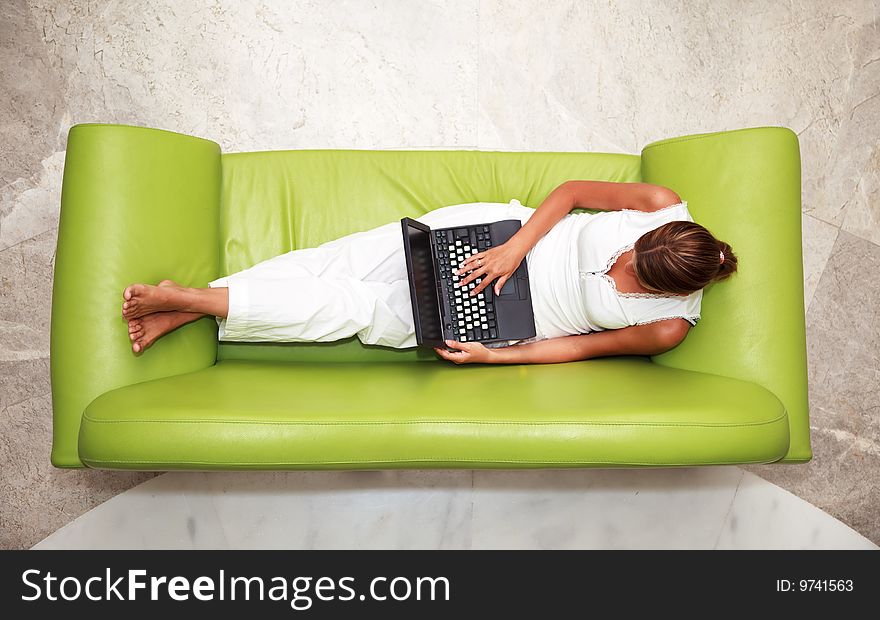 High angle view of a young woman using laptop while sitting on sofa