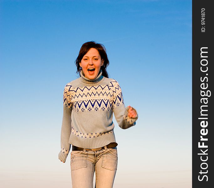 Happy young woman running at the field