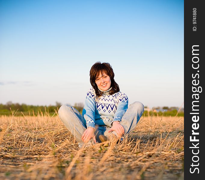 Smiling girl portrait outdoors with a field in the background