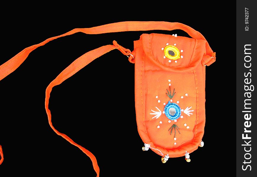 A bright orange ethnic mobile purse on a black background. A bright orange ethnic mobile purse on a black background
