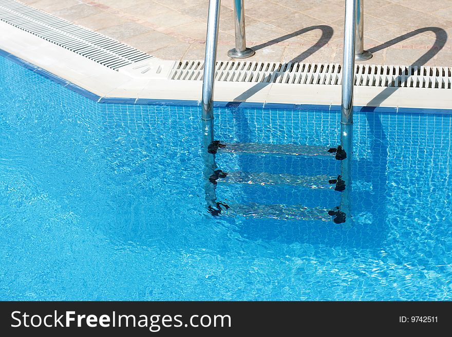 Handrail in swimming pool with blue water