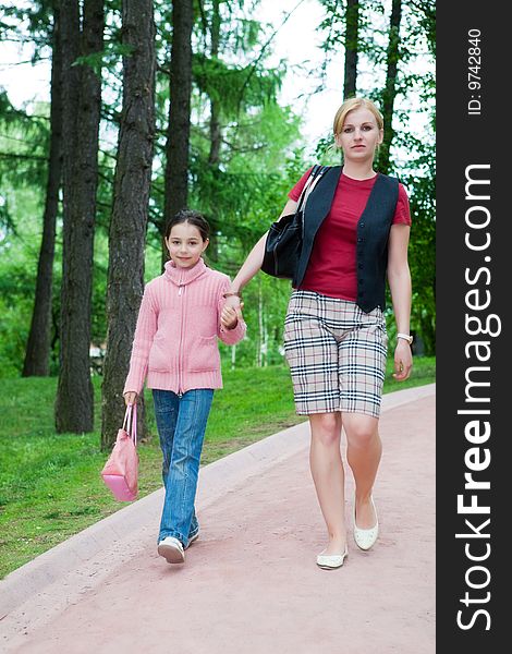 Mother and the daughter walk on a path in park. Mother and the daughter walk on a path in park