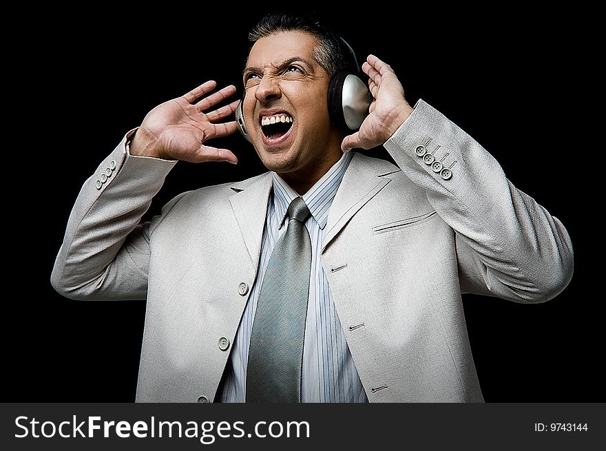 Side view of businessman listening music through headphone