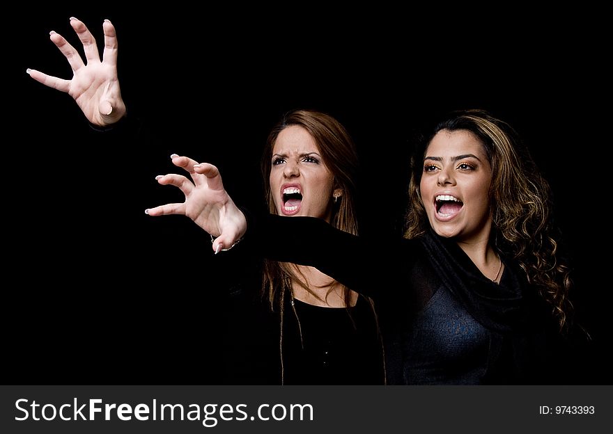 Portrait of shouting young women showing hand gesture
