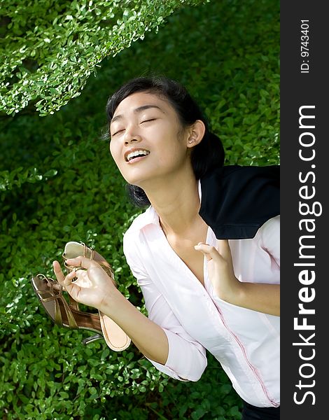 Conceptual portrait of pretty asian businesswoman in nature environment, seems to enjoy her break time from busy and stressful work life. Conceptual portrait of pretty asian businesswoman in nature environment, seems to enjoy her break time from busy and stressful work life