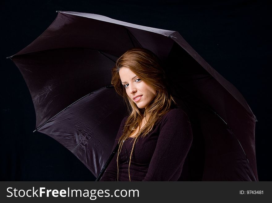 Portrait of smiling young female holding umbrella