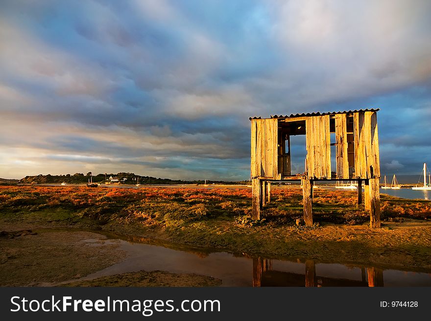 Landscape with old fishing hut and a vew to the sea port. Landscape with old fishing hut and a vew to the sea port