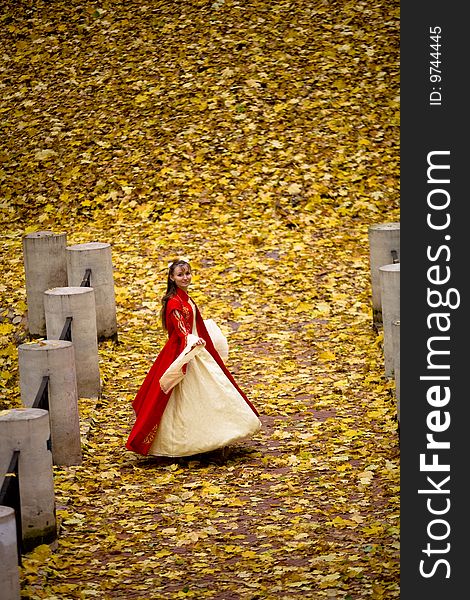 Lady in medieval red dress in the autumn forest. Lady in medieval red dress in the autumn forest