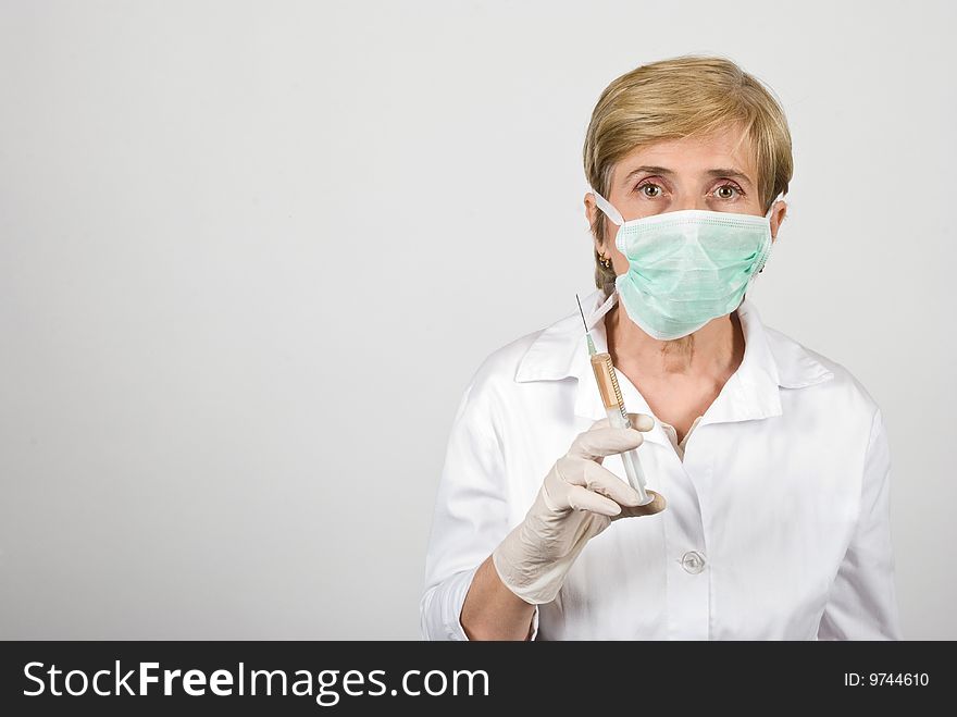 Senior woman doctor holding a syringe ,copy space for text message in left part of image,check also  <a href=http://www.dreamstime.com/medical-rcollection8351-resi828293>Medical</a>. Senior woman doctor holding a syringe ,copy space for text message in left part of image,check also  <a href=http://www.dreamstime.com/medical-rcollection8351-resi828293>Medical</a>