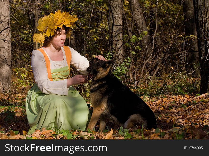 Woman and dog in autumn forest