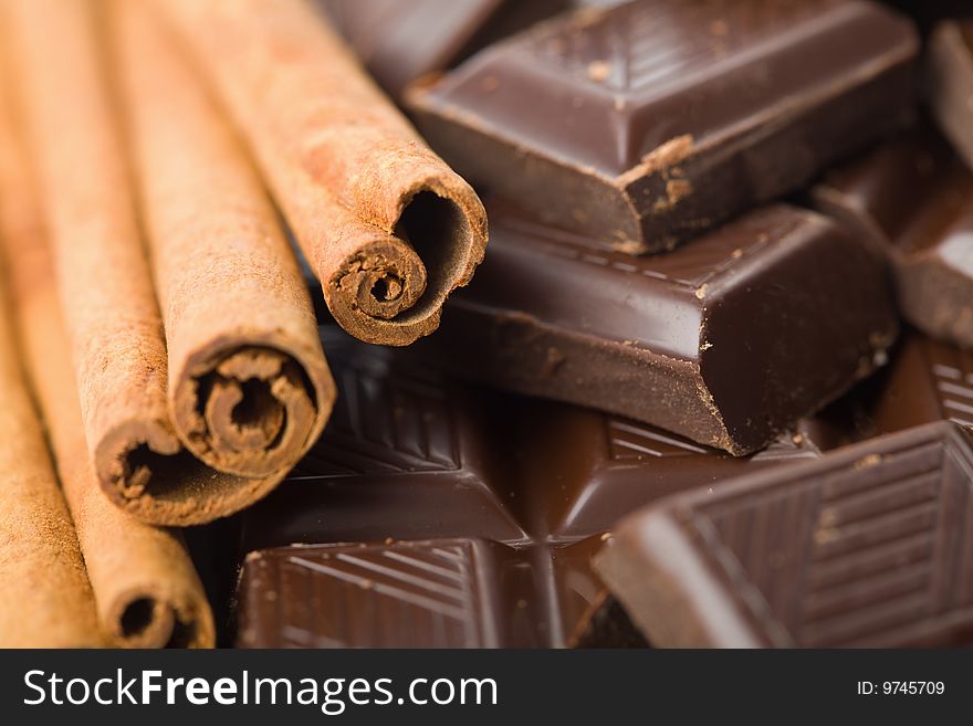 Macro of broken pieces of chocolate and cinnamon