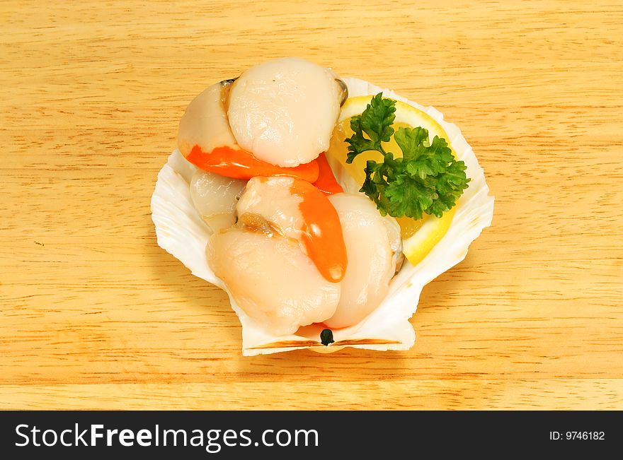 Raw scallops with garnish in a shell on a wooden board. Raw scallops with garnish in a shell on a wooden board