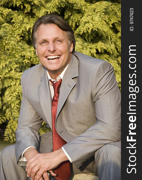 A colour portrait of a happy smiling businessman inhis forties looking up. A colour portrait of a happy smiling businessman inhis forties looking up.