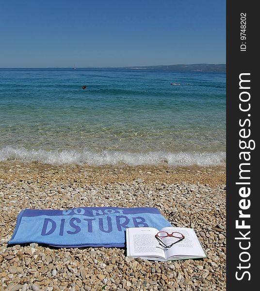 Wet towel do not disturb beach with blue-green sea. Wet towel do not disturb beach with blue-green sea