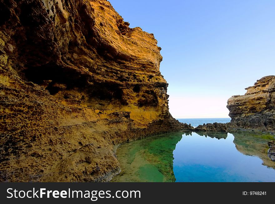 Steep cliff and calm water with reflections. Steep cliff and calm water with reflections