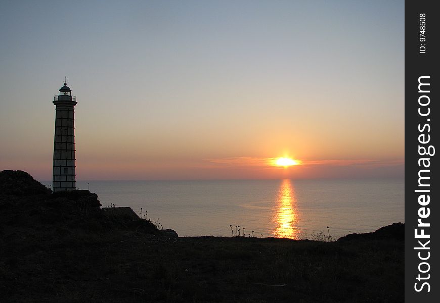 Wonderful sunset over the sea with a lighthouse