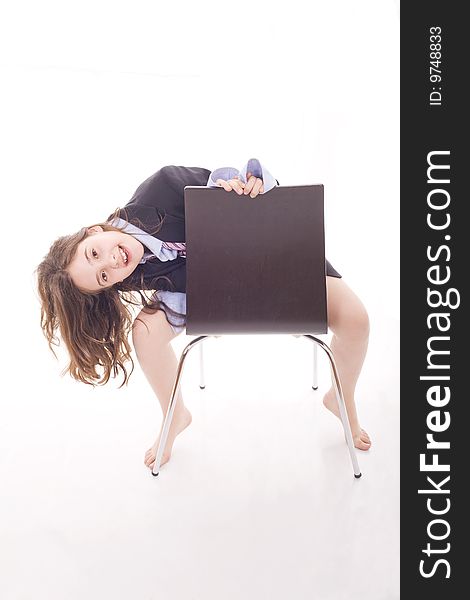 A young girl playing with adult's close and sited on a chair