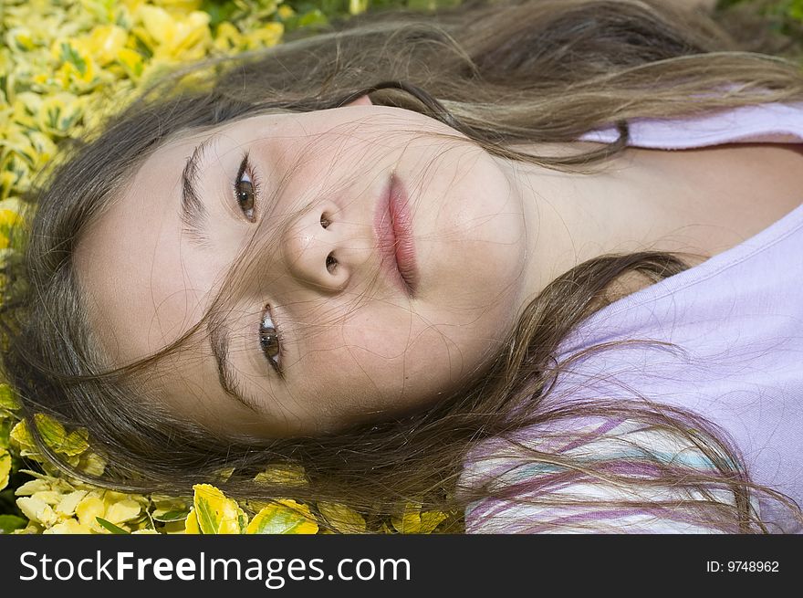 A young girl lying and resting on yellow flowers