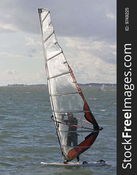 A wind-surfer cuts across the chill blue water of the Solent. A wind-surfer cuts across the chill blue water of the Solent.