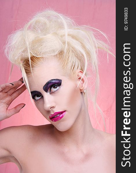 Young woman in pink portrait. violet make-up and big lips blonde funky hair style. Young woman in pink portrait. violet make-up and big lips blonde funky hair style