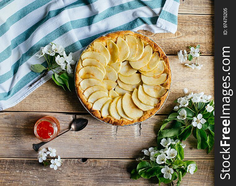 Apple pie with a blossom branch on table