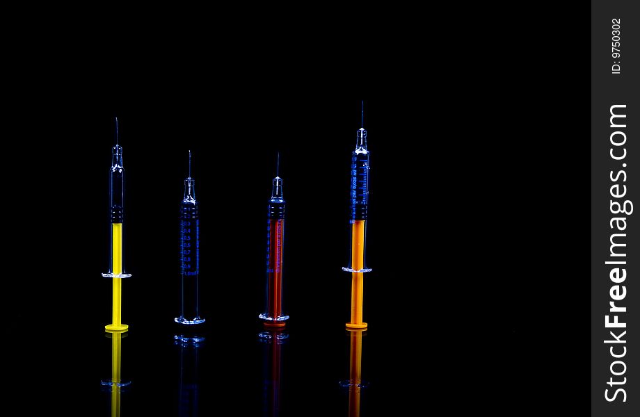 Color syringe on black background
