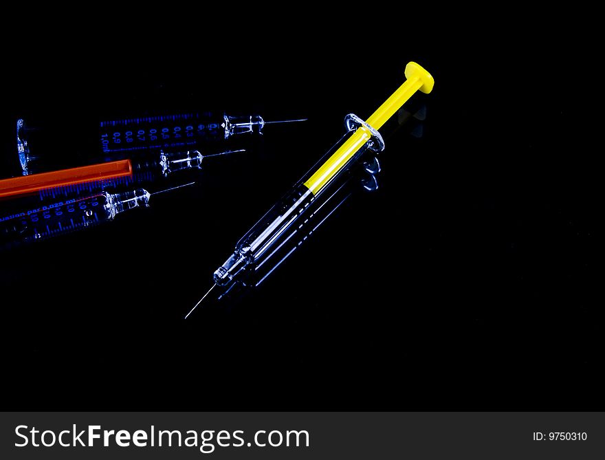 Color syringe on black background