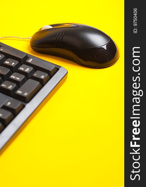 Computer mouse and keyboard isolated on yellow background