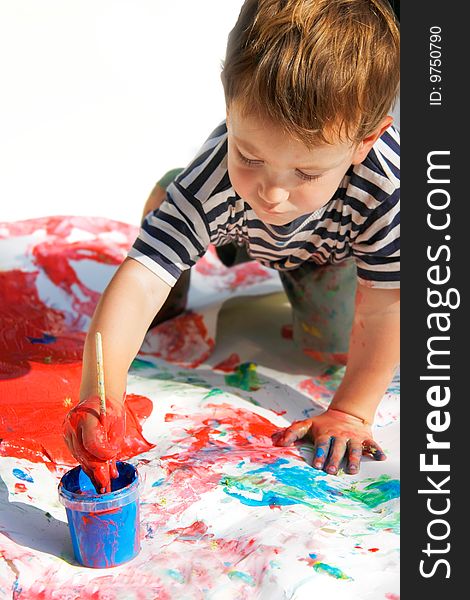 Young boy painting over white