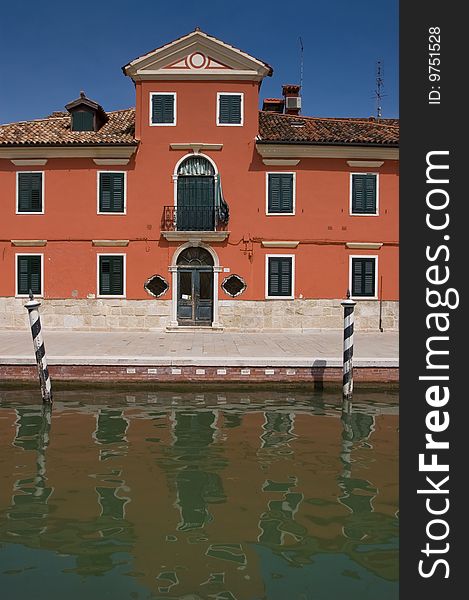 A beautiful canal in Venice with reflection of the house in the water. A beautiful canal in Venice with reflection of the house in the water
