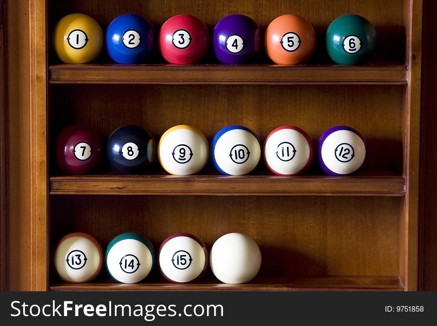 Photo of a billiard balls on a shelf.