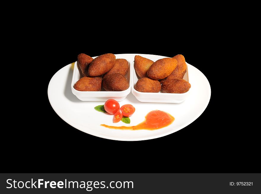 Fried dumplings on plate white, background black, with sauce and tomatoes