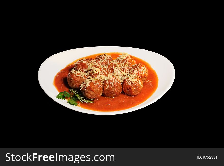 Meatballs with sauce and grated cheese, white plate, background black