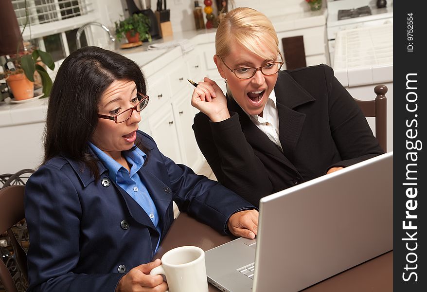 Businesswomen Celebrate Success on the Laptop in the Kitchen.